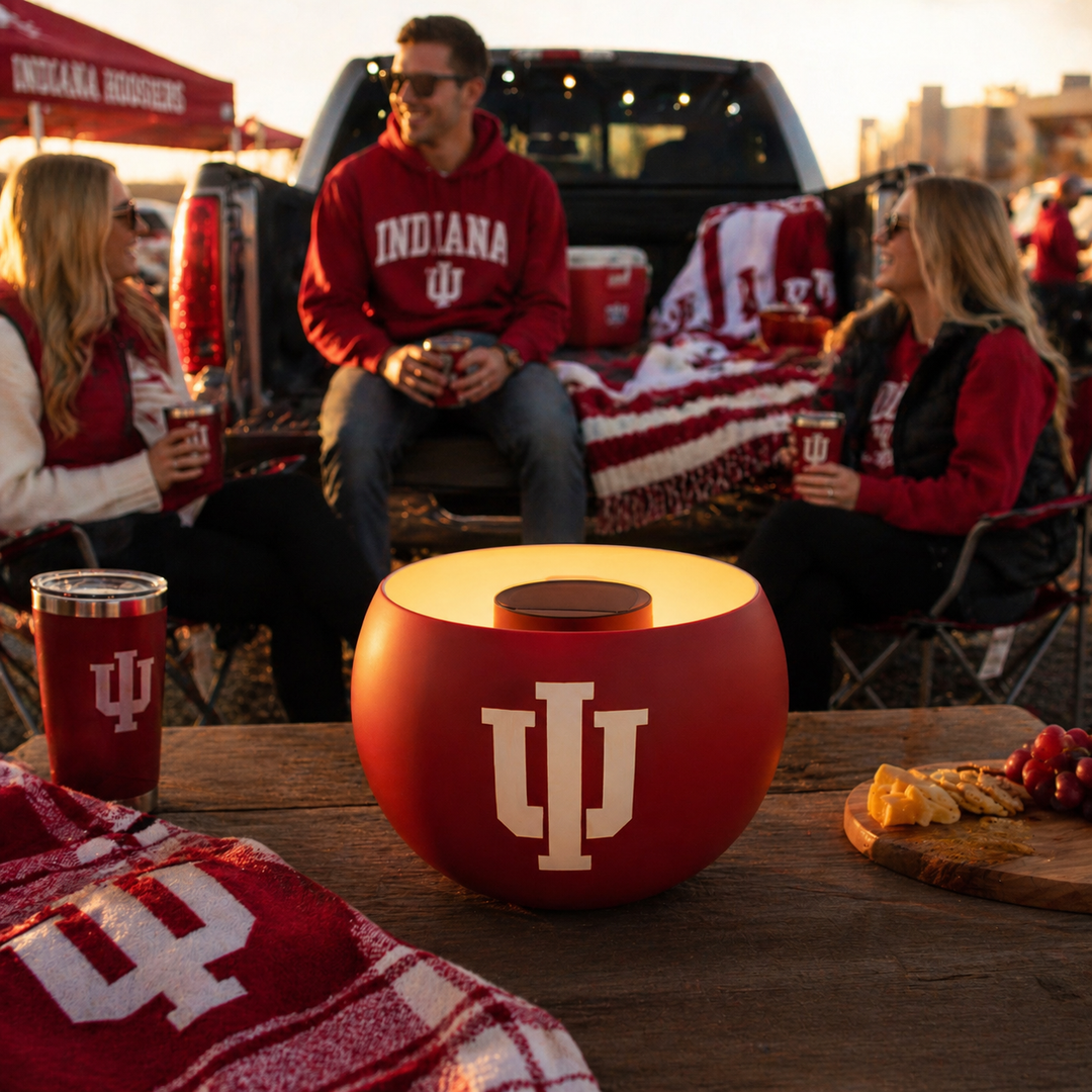 People tailgating with Indiana University-themed items including a red bowl with a large 'IU' logo.